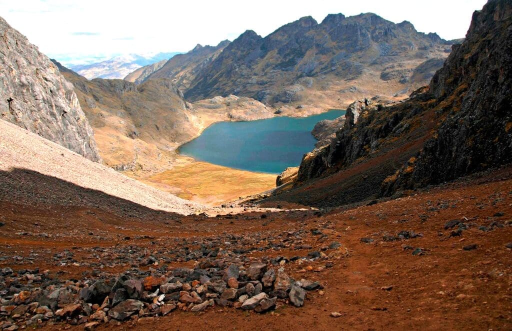 lake at the base of rocky mountains in Cusco, Peru