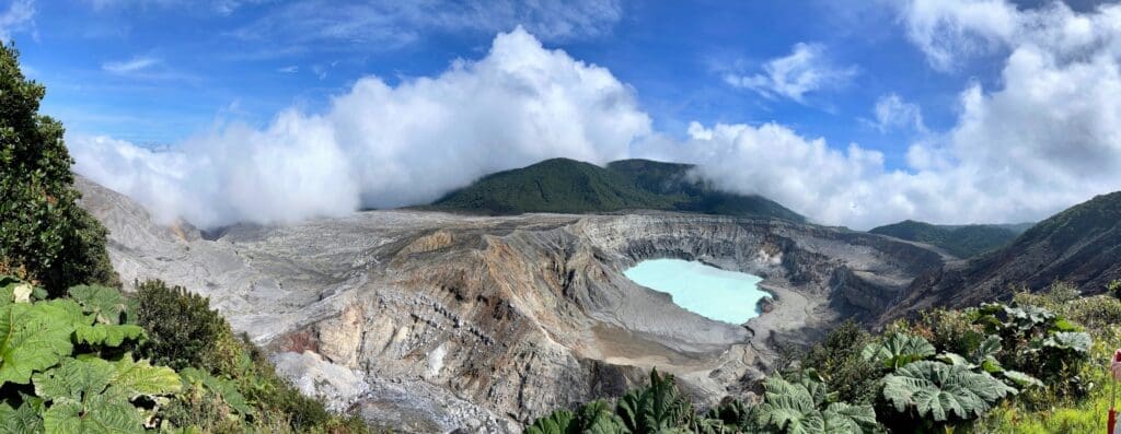 milky volcano lake surrounded by mountains in the clouds