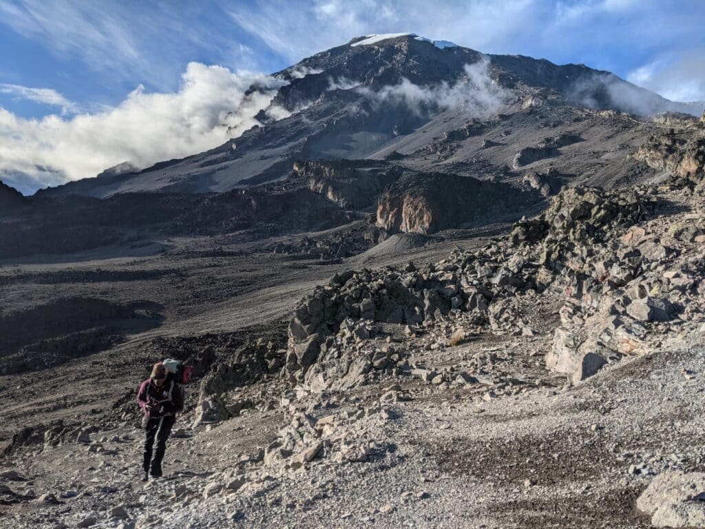 Snow-capped summit of Mount Kilimanjaro peeking through clouds