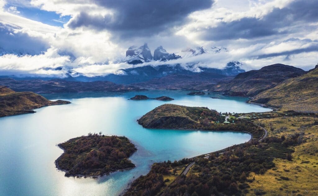 A view of the mountains of Torres del Paine National Park in the distance. A large turquoise lake is in the foreground