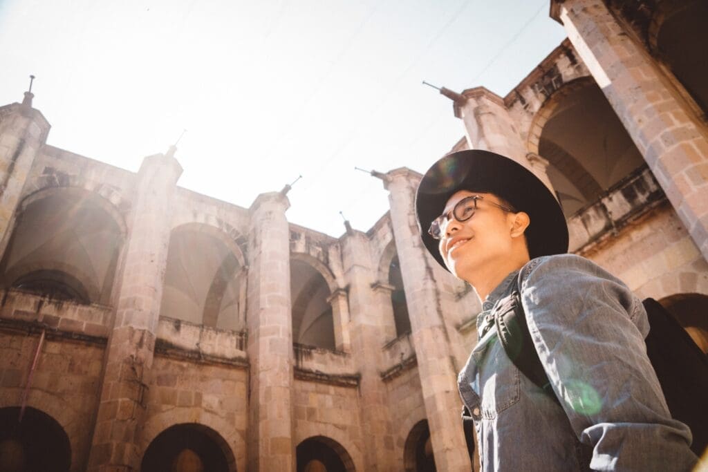 Smiling man traveling alone and touring a historic building.